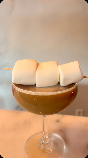 Cocktail topped with skewered marshmallows